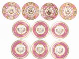 six assiettes roses et blanches, ornées de bordures dorées sur un fond blanc
