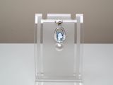 une petite vitrine contenant une pierre bleue et un pendentif en perle