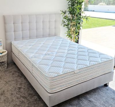 une photo d'une chambre avec un lit et une plante