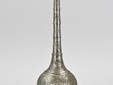 un vieux vase en métal argenté à long col sur fond blanc