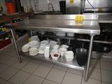 a stainless steel table with bowls and pans on it