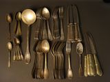 a lot of spoons and spoon knives on the table