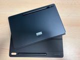 two laptops sitting on top of each other on a wooden table