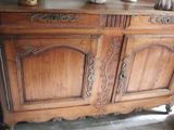 a wooden cabinet that has a vase on top of it