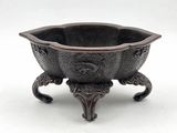a metal bowl that is on a stand on a white surface