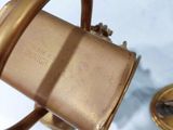 a small brass object sitting on a table next to a small brass object