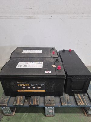 Deux batteries sont posées sur une palette dans un entrepôt