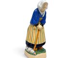 figurine représentant une vieille femme avec une canne, sur fond blanc