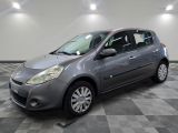 La petite voiture grise est garée dans le garage, sur un sol à damier.