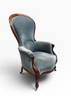 une vieille chaise dont l'assise est recouverte d'un tissu bleu