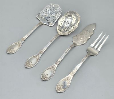 quatre cuillères en argent et une fourchette sont alignées sur une table