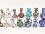 many different colored vases sitting on a white surface
