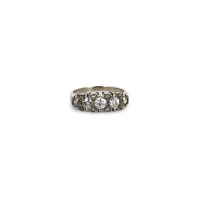 un gros plan d'une bague sertie de trois diamants sur fond blanc