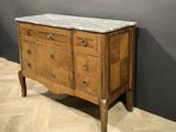a marble top chest of drawers on display in a room