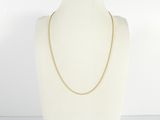 a white mannequin torso with a gold chain on it