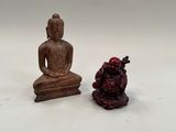 deux figurines de bouddhas assis l'un à côté de l'autre sur une surface blanche