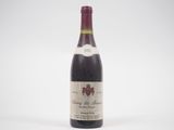 une bouteille de vin rouge posée sur une table blanche
