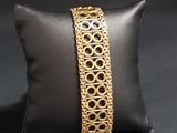 a close up of a pillow with a gold bracelet on it