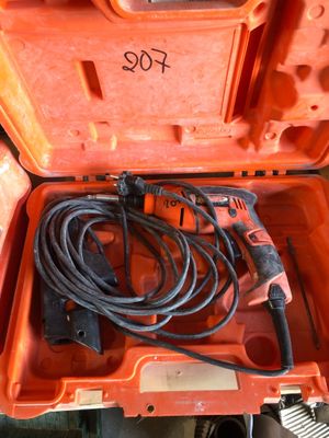 une boîte à outils orange contenant un cordon et une perceuse