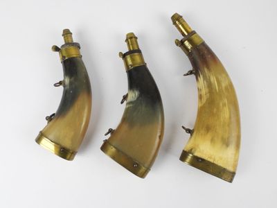 three horn horns with brass fittings on a white background