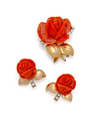trois broches rouges et dorées sur fond blanc