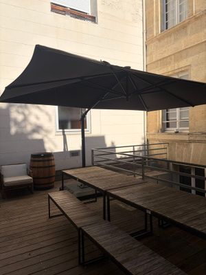 a black umbrella that is on top of a wooden table
