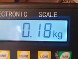a digital scale on a table with a clock on it