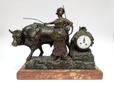 a bronze statue of a woman on a oxen with a clock