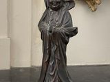 une statue représentant un homme tenant une canne devant un miroir