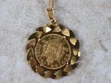 a close up of a gold coin on a gold chain