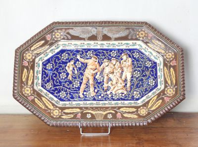 un plateau décoratif orné d'une peinture, posé sur une table en bois