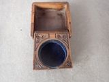 a small wooden box with a blue glass inside of it