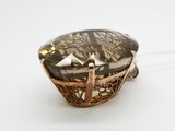une image représentant un pendentif orné d'une grosse pierre facettée sertie dans un cadre en forme de panier
