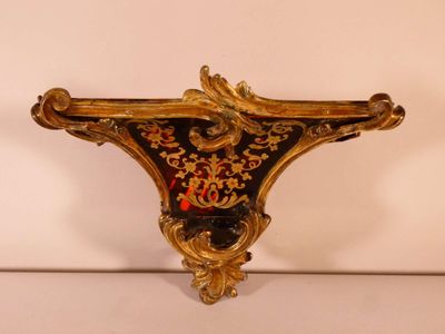 une étagère dorée et noire sur laquelle se trouve une horloge