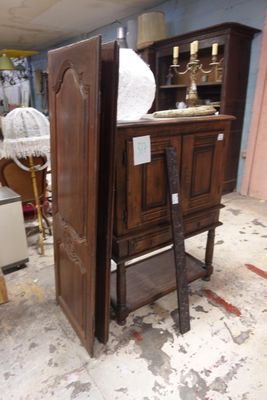 une armoire en bois au milieu d'une pièce, avec une échelle devant