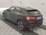 the rear end of a grey car parked in a garage