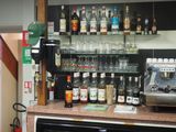 many bottles of alcohol on the counter behind the bar