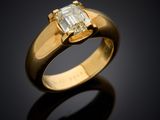 a close up of a gold ring with an emerald stone