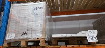 une palette remplie de cartons, elle-même posée sur une autre palette, dans un entrepôt