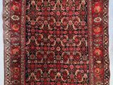 un tapis persan ancien aux couleurs rouges et bleues