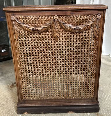 une vieille armoire en bois dont la façade est ornée de motifs sculptés