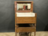 une commode en bois surmontée d'un miroir