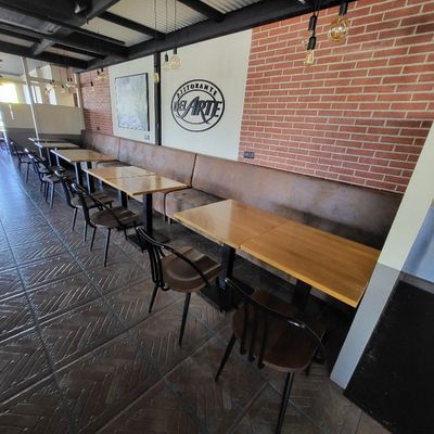 des tables et des chaises dans un restaurant aux murs en briques et au plafond apparu