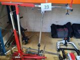 une photo d'un établi dans un garage, avec des outils posés par terre