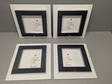 three black and white frames with writing on them sitting on a table