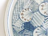 a blue and white plate with a lot of buttons on it