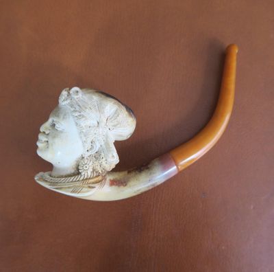 a picture of a pipe with a carved head on it