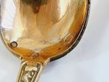 a gold spoon with a picture of a woman on it