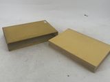 two gold books sitting on top of a white surface