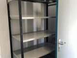 a metal shelf with shelves in the corner of a room
